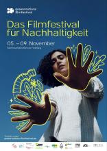 Das Poster des Festivals: Eine Person in weißem Pulli streckt ihre Hände in Richtung der Kamera. Der Hintergrund ist blau