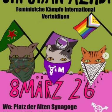 Auf dem Plakat sind drei Katzen mit Vermummung zu sehen. Die rechte Katze trägt eine Kufiya, die Katze in der Mitte ein 8M-Tuch und die linke Katze trägt ein kurdisches Tuch. Hinter den Katzen sind drei Flaggen zu sehen: Rechts die Queer-Flagge, in der Mitte die feministische Aktionsflagge und links die YPJ Flagge. Die Katzen halten ein Banner, auf dem steht: „8. März 2026"